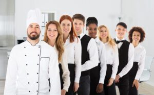 A portrait of a chef, waiters, and waitresses in professionally cleaned uniforms.